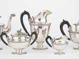 un service composé de cinq théières et cafetières en argent avec des anses noires
