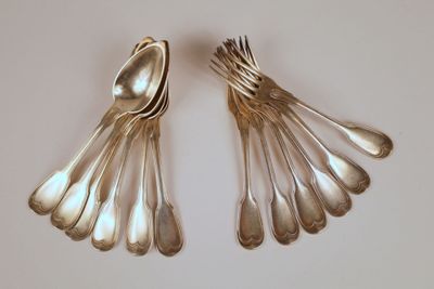 deux cuillères et une fourchette sur une surface blanche