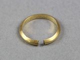 gros plan d'une bague en or sur une surface blanche