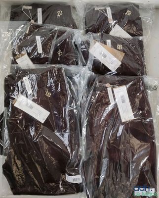 six brown shirts wrapped in plastic bags on a table