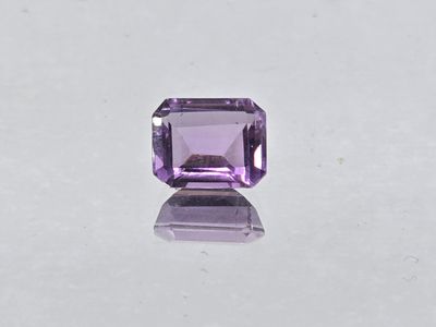 a purple amethorate stone on a white surface