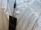 a white shirt hanging on a hanger in a store
