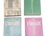 four books of different colors and designs on a white surface