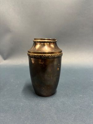 un vase doré posé sur un fond bleu