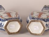 pair of blue and white vases with figures on them on a table