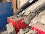 a red and black blow dryer sitting next to a blue and white trash can
