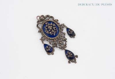 an image of a blue and silver broochle with a flower on it
