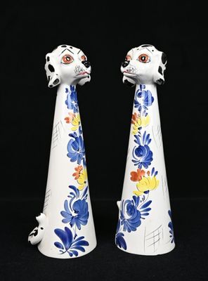 paire de figurines en céramique bleues et blanches représentant un chien et un chat sur fond noir