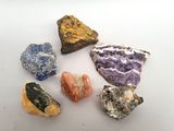 un ensemble de pierres de différentes couleurs posées sur une surface blanche