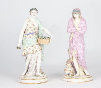 pair of porcelain figurines of women with baskets of flowers
