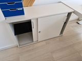 un bureau blanc sur lequel est posé un classeur bleu