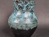 a blue and black vase sitting on a table