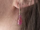 a close up of a woman wearing a pair of pink earrings