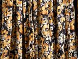 a close up of a yellow and black floral print dress
