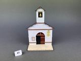 a small white building with a clock on top of it