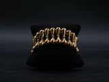 un gros plan d'une bague plaquée or posée sur un coussin noir