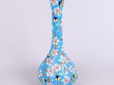 un vase bleu avec des fleurs posé sur une table