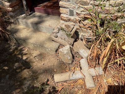 une croix posée par terre à côté d'un bâtiment en briques