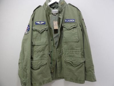 a green jacket hanging on a wall next to a hanger