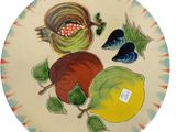 une assiette sur laquelle sont représentés des fruits et un oiseau