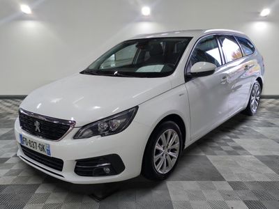 la voiture blanche est garée sur un sol en damier dans le garage