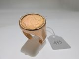 une bague sur laquelle est posée une pièce et à laquelle est attachée une étiquette de prix
