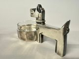 a silver dog shaped object next to a glass of water