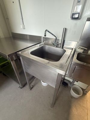 a stainless steel sink in the middle of a kitchen