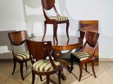 several chairs and a table in a room with a white wall