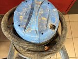 a blue machine that is sitting on a tiled floor