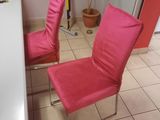 two pink chairs that are sitting in a room