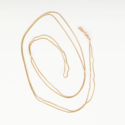 un collier en or avec une chaîne en or et un fond blanc