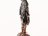 statue of a man standing on a stack of books on a white background