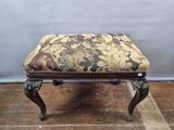 un petit tabouret avec une assise rembourrée à motifs floraux