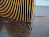 a wooden radiator that is on the floor next to a wall