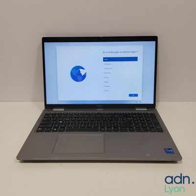 un ordinateur portable ouvert posé sur une table blanche