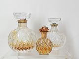 two glass vases sitting on top of a clear shelf