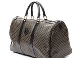 a brown and black duffel bag sitting on top of a white surface