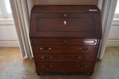 a small wooden desk with a drawer on top of it