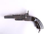 un gros plan d'un pistolet sur une surface blanche avec un fond blanc