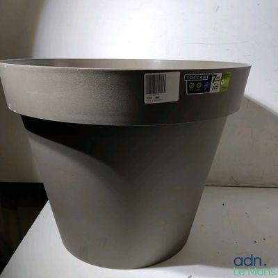 a gray planter sitting on a table with a tag on it