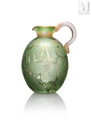 un vase vert muni d'une anse blanche, posé sur une surface blanche