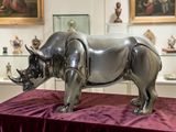 a rhino statue sitting on a table in a museum
