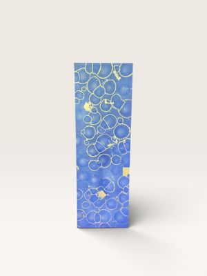 une boîte bleue ornée de bulles, posée sur une surface blanche