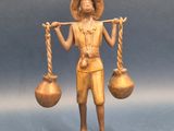 figurine en bronze représentant un homme tenant deux cruches d'eau et une corde