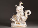 a figurine of a woman sitting on a dragon