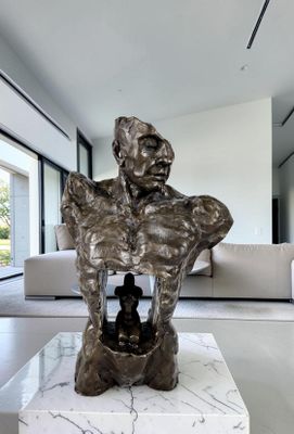 une statue représentant un homme assis sur une table dans un salon