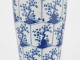 un vase bleu et blanc posé sur une surface blanche