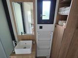 a small bathroom with a toilet, sink, and a window