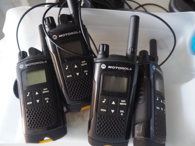 quatre talkies-walkies Motorola posés sur un plateau blanc